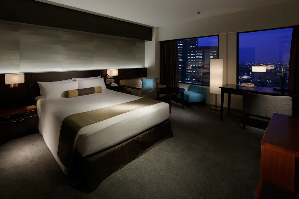 "Plaza Luxe King", with 40.8 square meters room area. The art wall made of custom made Japanese paper accentuates the space, illuminated by the indirect lighting of the head board.