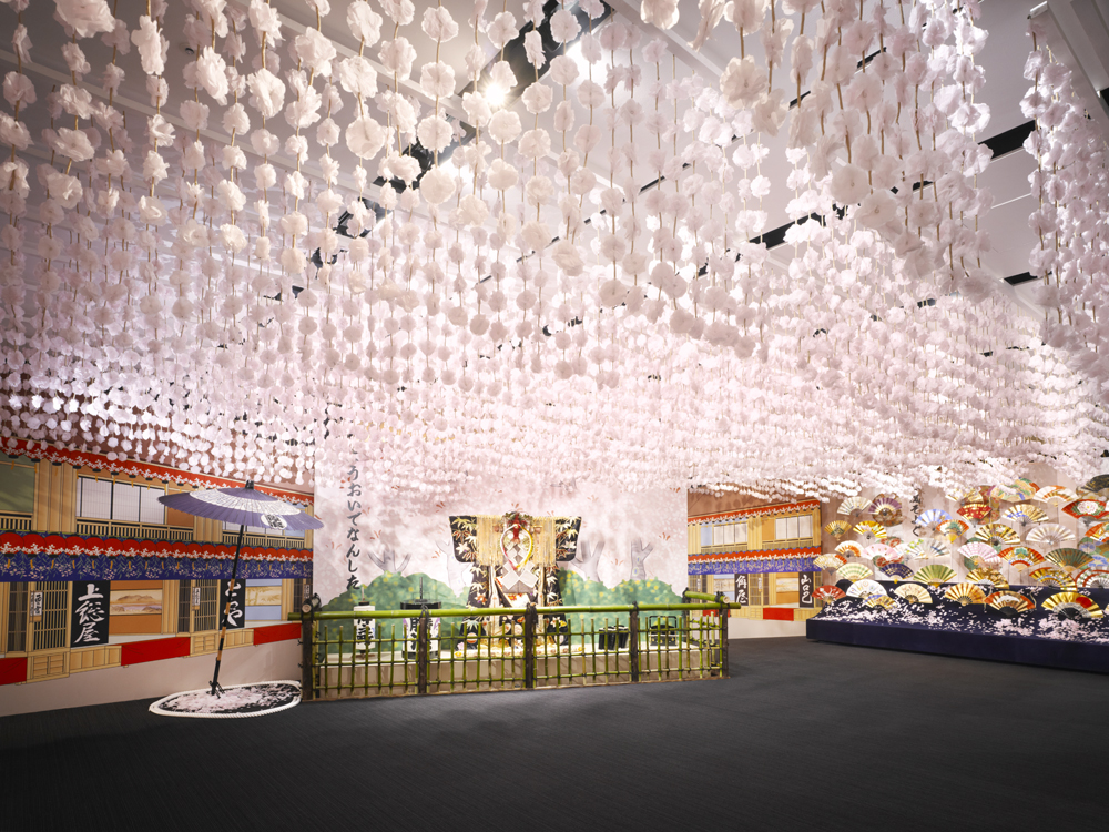 A full view of the venue. The entire ceiling is covered with hanging cherry blossom branches, with tools from Yoshiwara Nakanocho in the background.