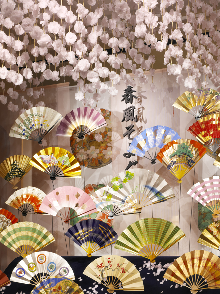 A colorful folding fan used on stage. It sways gently along with the cut-out title, Spatial Production a serene spring scene.