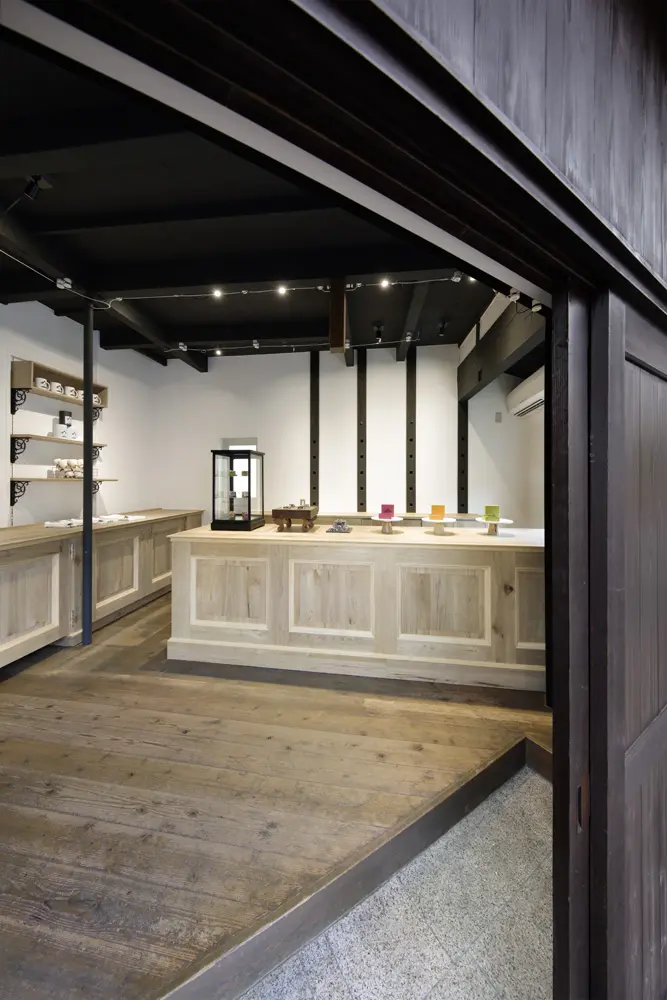既存を生かした床や天井、京料理屋のカウンターのような白木、「洋」の重厚な什器を対比させたコンセプチュアルな空間。
