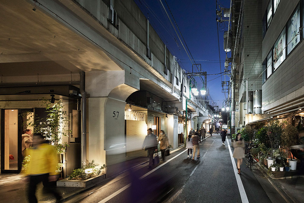 既存商店と道を挟んで並ぶ高架下の商店街、既存のにぎわいと呼応する両側町を形成