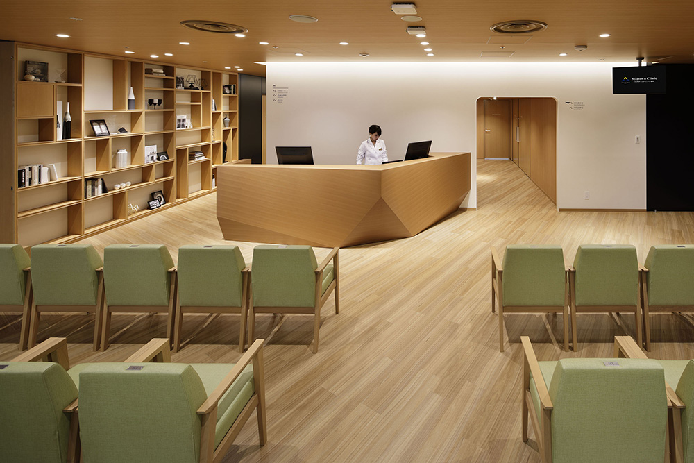 男性健診の待合：動線や各室の機能を整理し、床貼りの向きや壁の色、サイン計画に落とし込んでいる