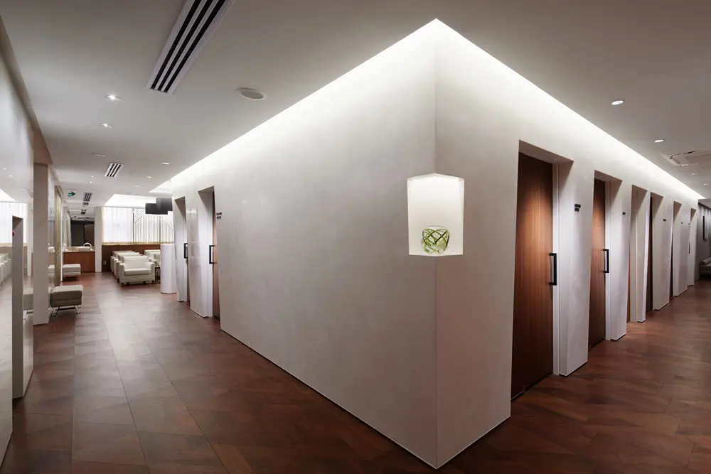 女性専用の人間ドックフロアの入口：木を基調とした重厚な共用部から入ると、白く明るい空間が広がる