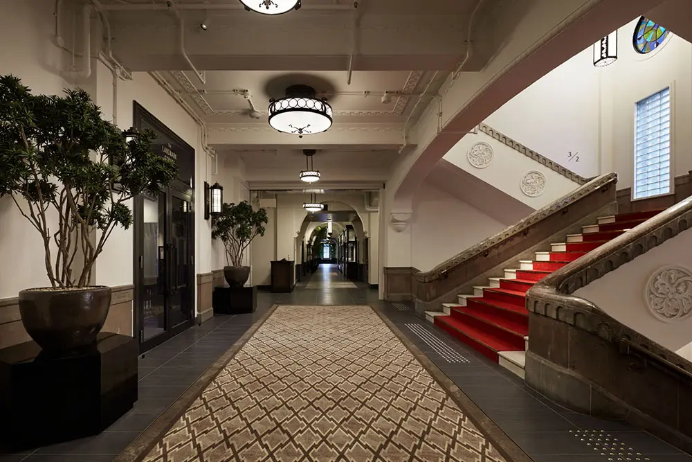 Common areas within the facility. The public spaces were renovated to make the most of the existing architecture, including the stairs, handrails, columns, structure, and stained glass.