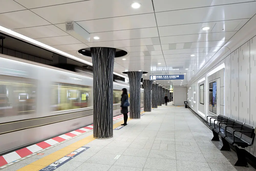 Hibiya Line platform: The frames on the white walls seem to float in this exhibition space while the pillars give a feeling of trees swaying in the wind made by the aluminum framed trains going by.