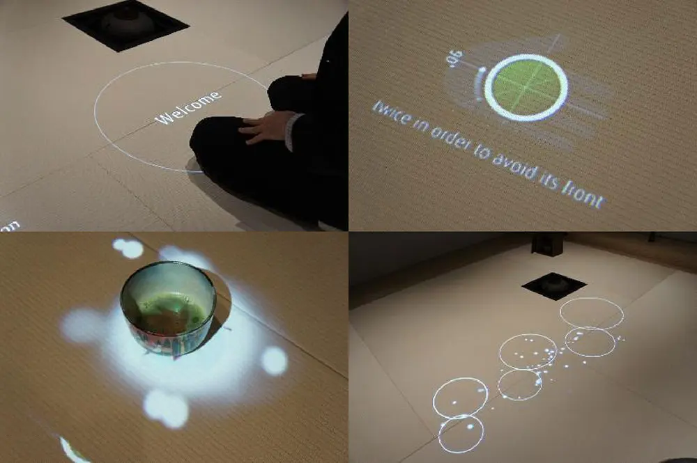 茶事の流れを妨げず、茶道の作法を⽰し、さりげなく次の⾏動を促すなどの演出をその場の状況を読み取るセンシングを使用し、モーショングラフィックスで自律的に行う
