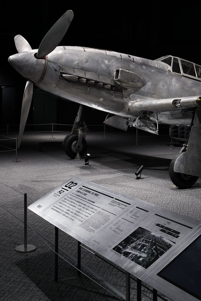 航空エリアの三式戦闘機二型「飛燕」実機展示。各務原で生まれ、紆余曲折を経て帰郷しレストアされた機体。塗装が剥がされアルミ剥き出しの迫力ある姿を引き立たせるように空間・照明をデザイン