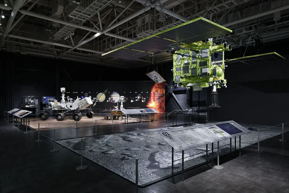 太空区域的太空探索区。展示宇宙中生命探索的热点情况。右边是到达小行星Ryugou的“隼鸟2号”的实际尺寸模型。背面的墙壁每天更新太阳系的大型图形，可以更新太空探索的结果