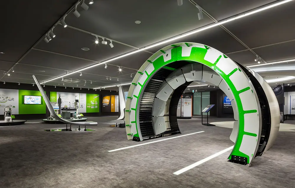A display of life-size assembled aircraft parts. In the back, the medical business is introduced. Each business is arranged in layers so that it can be seen overlapping.