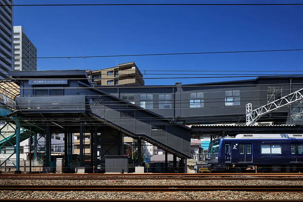 デザインガイドラインで定めたダークグレートーンでまとまった駅に「YOKOHAMA NAVYBLUE」を装った車両が入線。駅舎、車両等をトータルでデザイン
