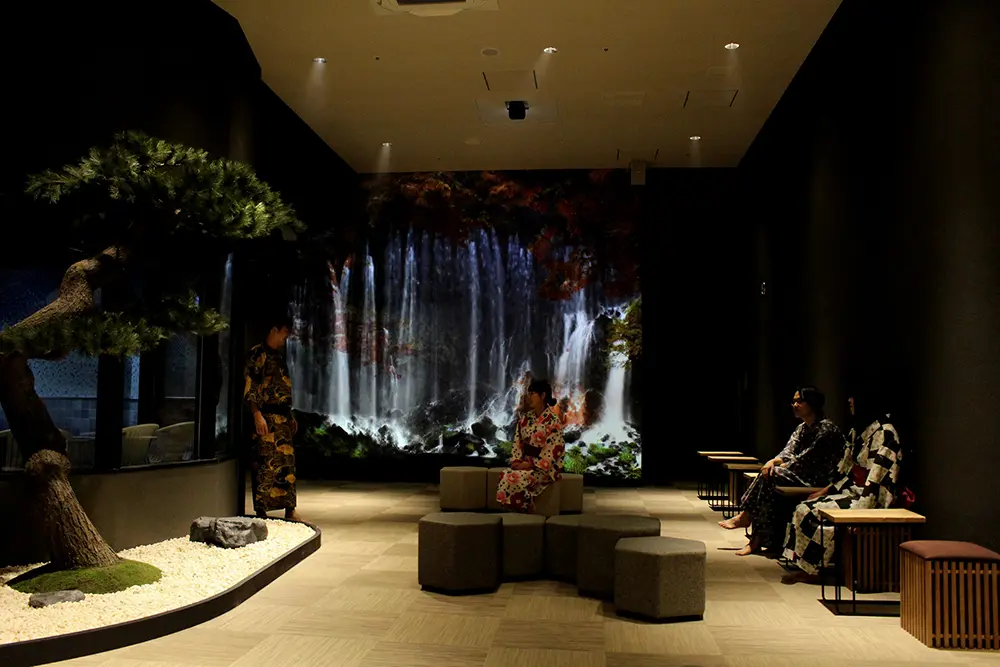 With seasonal Video projected onto a waterfall graphic and pine tree ornaments, the rock sauna rest lounge feels like an outdoor bath with a refreshing feel.