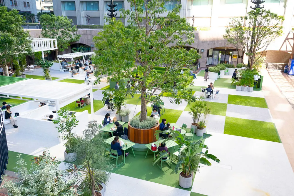 By utilizing the open atrium and placing tall trees appropriately, the space blends healing with the city.