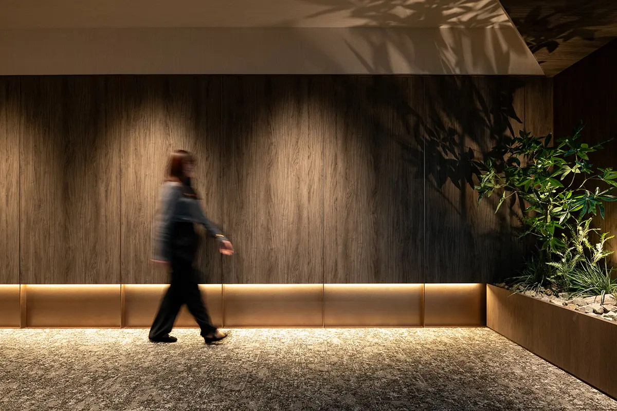 The shadows created by the lighting and the sunlight filtering through the trees on the ceiling create a sense of peace during business meetings.