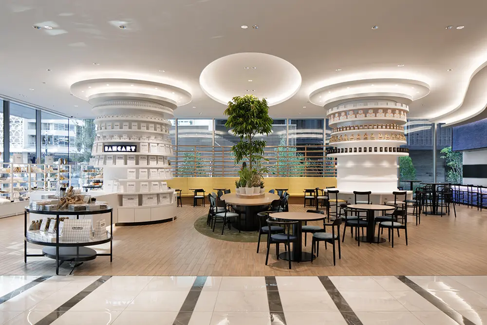 A cafe area integrated with shops plays a central role in creating a lively atmosphere