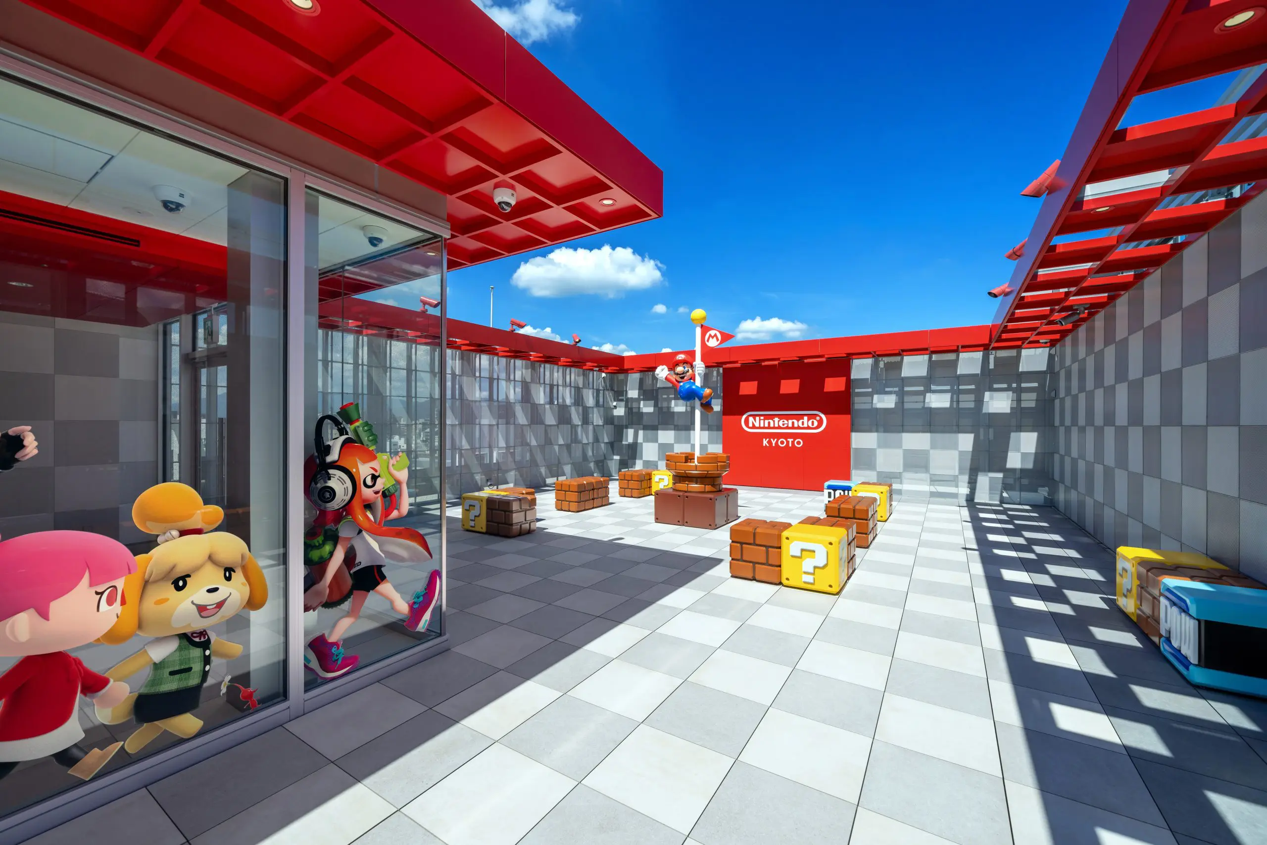 A plaza on the rooftop with Mario in the center holding onto the goal pole.

