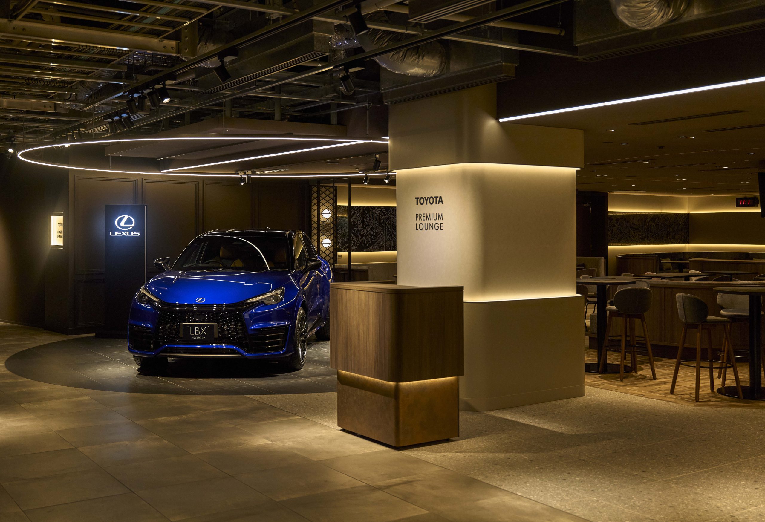車展示と飲食エリアが心地よく共存するラウンジ。レセプション付近のハイカウンター席は試合の合間に素早く食事を楽しめる