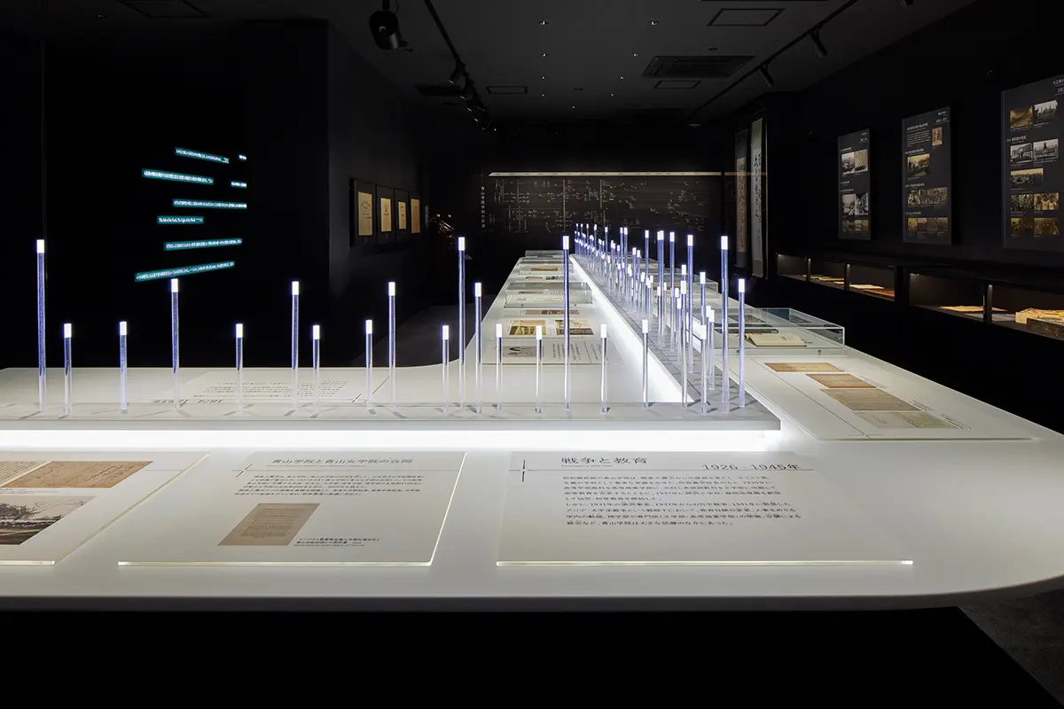 Aoyama Gakuin's History ②: Light of the Trajectory | A table in the center of the room is adorned with 150 illuminated rods that weave together the school's 150-year history, Spatial Production a space that connects the school's history.