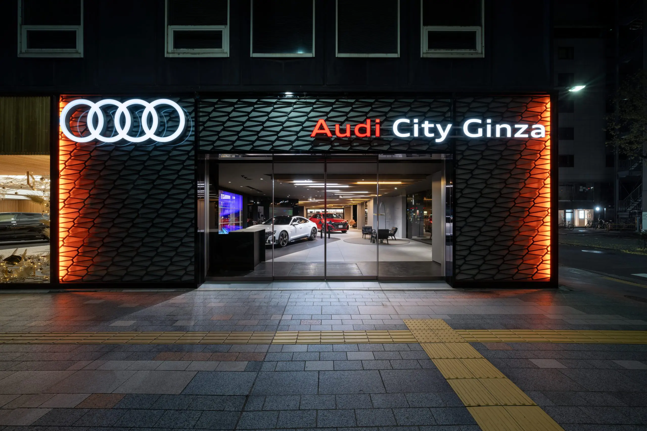 夜間の銀座の街並みの中で存在感を放つファサード