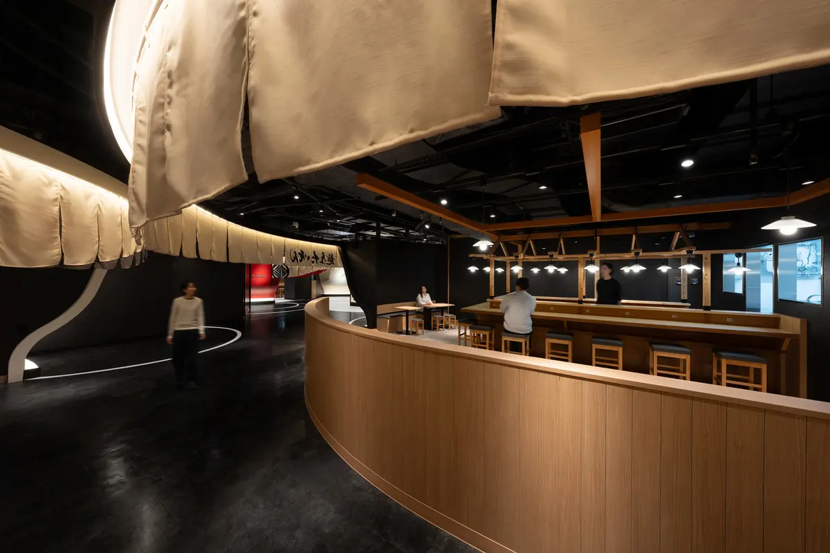 暖簾と店舗外装の境界線をずらすことで、店内スタッフとは目線を通し、通路側の席とは目線が合わない設計とした