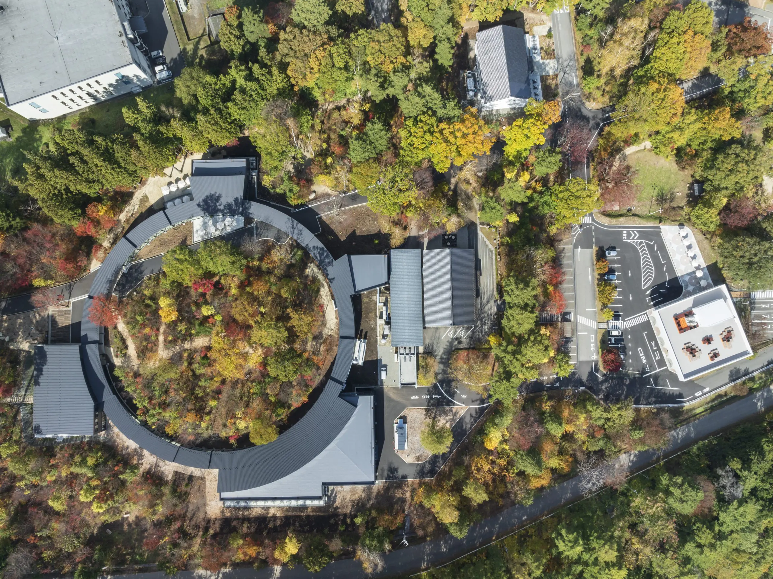 既存の森を囲む 直径８０ｍの屋内回廊「Forest Ring」。その隣に養命酒発祥の地から移築した二棟の蔵を配置