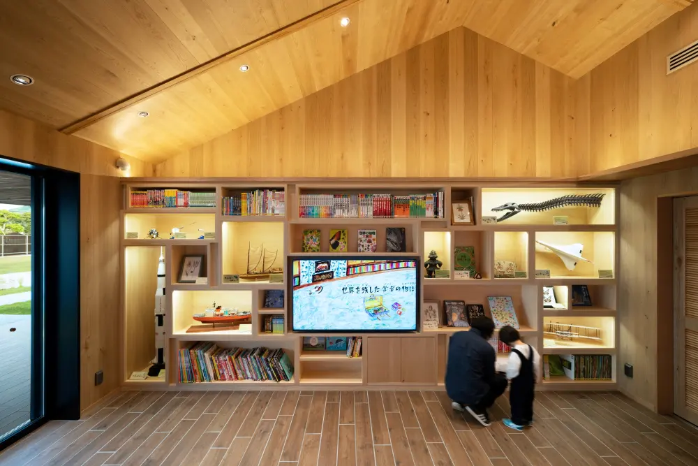 Traveling Shelf: A collection of items symbolizing the worlds the scholar has traveled through. Picture books are displayed in the center as Digital Contents