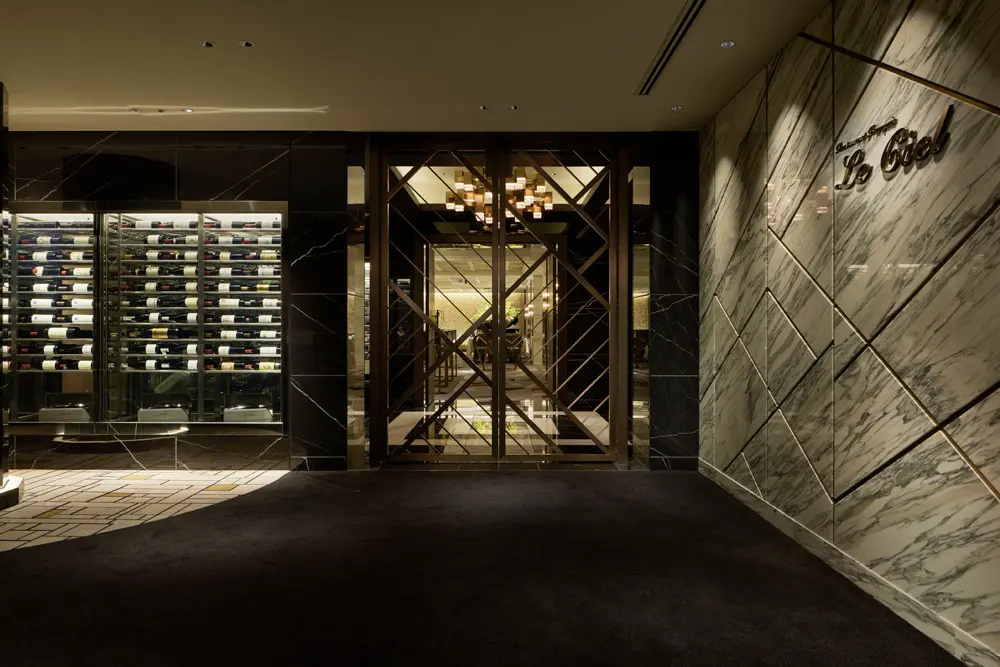 The marble (arabescato) walls and large doors incorporating the geometric design of Satsuma Kiriko glass enhance the luxurious feel of the façade.