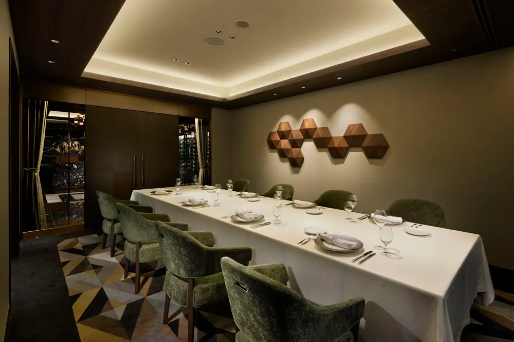 A special private room connected to a walk-in wine cellar. Geometric wooden art decorates the space.