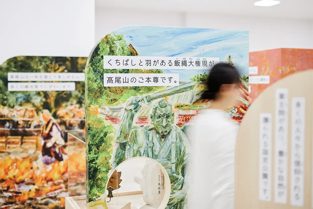 An exhibition room decorated with 18 illustrations symbolizing the history of Hachioji, and featuring a variety of documents and Video content.