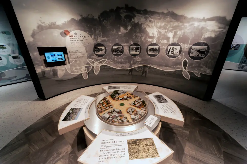 The site where the Battle of Okinawa ended: A sculpture of the Itoman Rotary, a symbol of the city, is recreated. A monochrome world view shows the city's recovery from rubble.