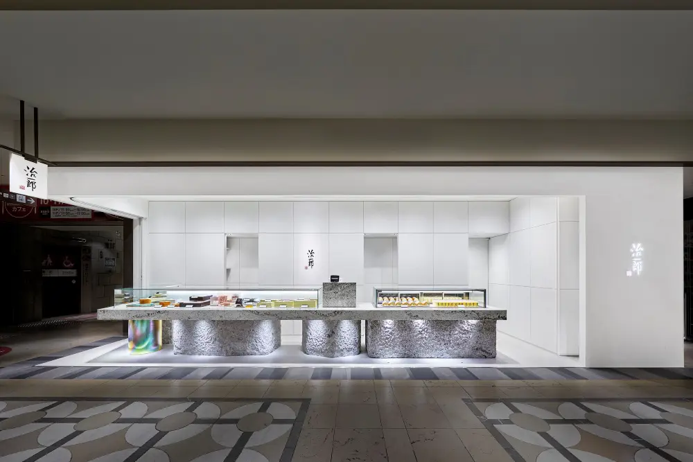 Jiichiro Tennoji Mio商店:通过采用白色花岗岩，产品在陈列柜的材料上闪耀，我们为Jiichiro品牌承诺的糖果创造了一个强大而美丽的“舞台”