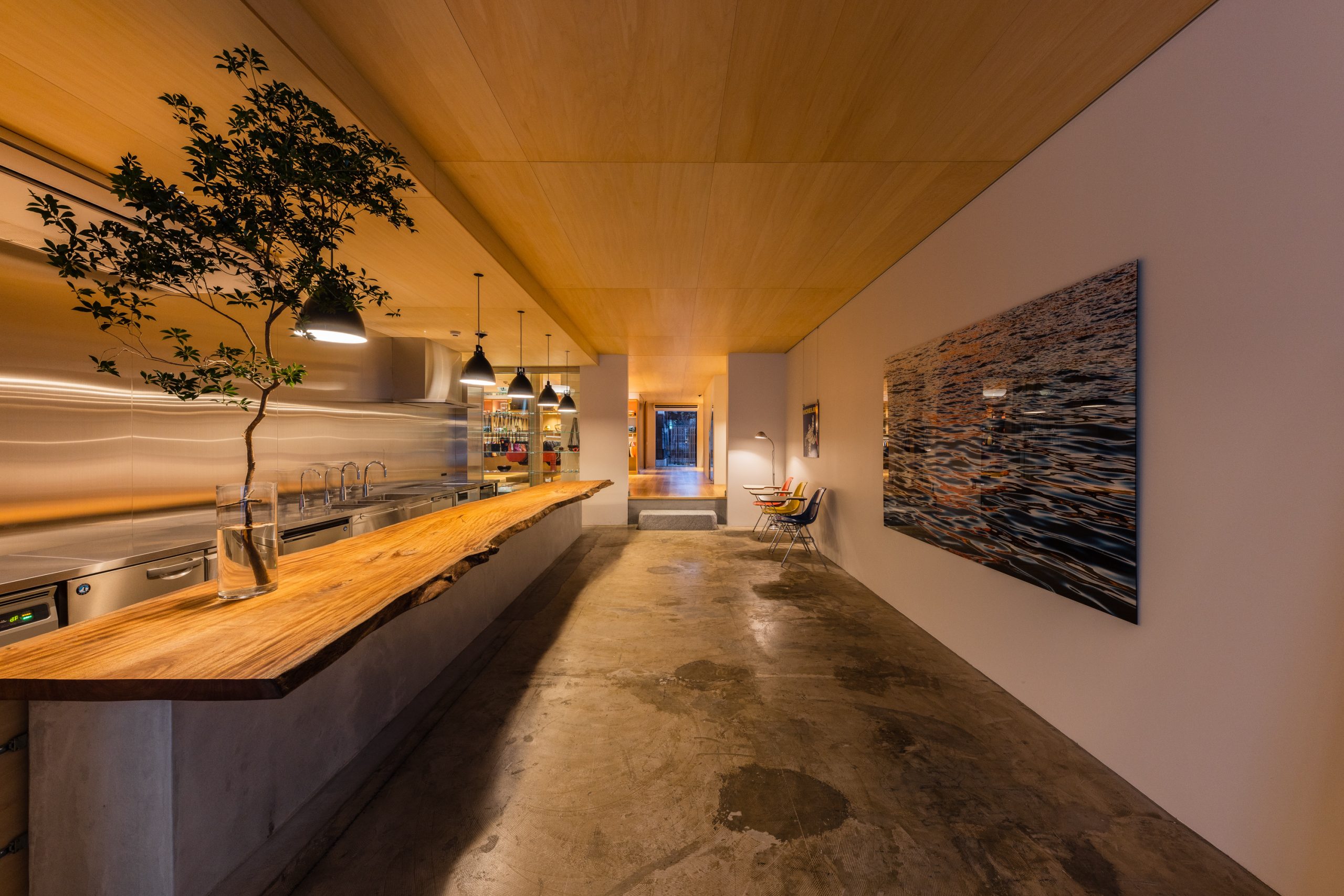 The earthen floor area is located right at the entrance on the first floor. Behind the raised area you can see a garden filled with sunlight and a breeze passing through. It evokes the original appearance of a traditional townhouse with depth.