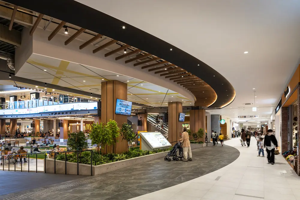 The open-ceiling rest area is treated as a central node, and a ring-shaped design that can be seen from the mall is used, creating a sense of unity between the food hall and the open-ceiling space.