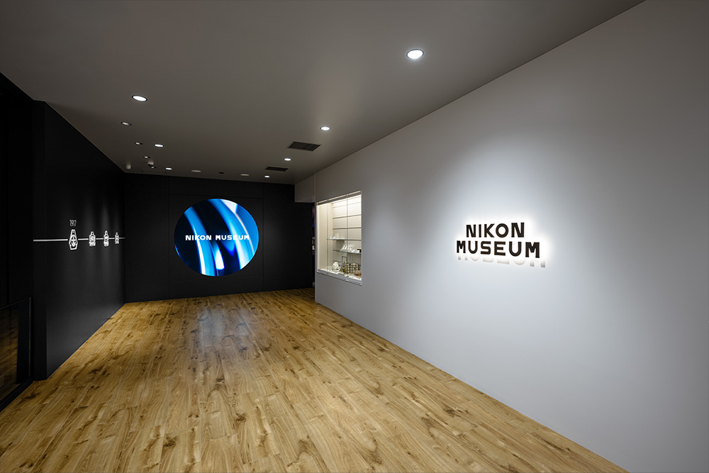 エントランスゾーン：ニコンの原点である光学ガラスの歩みの一部を展示。「光の力で未来を拓く」をテーマにした円形スクリーン映像がエントランスでお出迎し、展示への期待を醸成させる