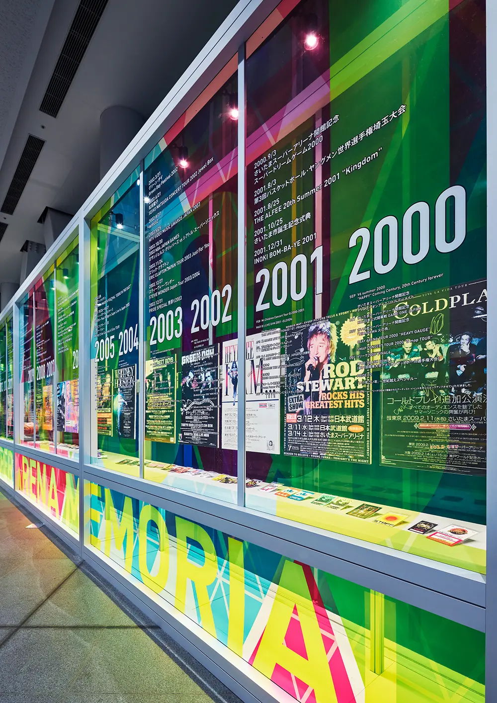 The case displays items related to the event, such as posters and staff passes.